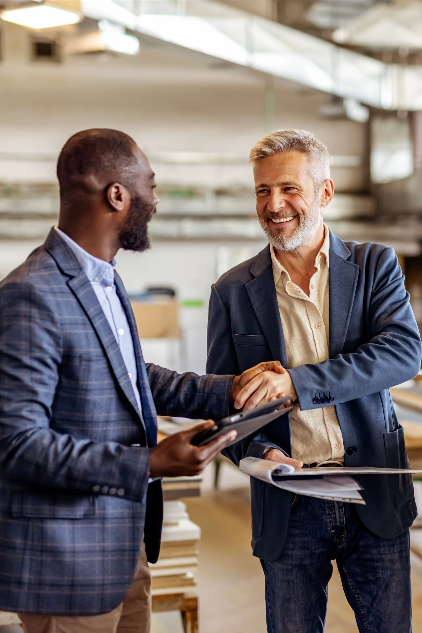 Two business professionals shaking hands in a modern office